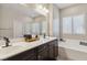 Bathroom featuring double sinks, soaking tub, and white countertops at 6731 Sumatra St, Las Vegas, NV 89166