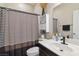 Cozy bathroom featuring a shower with a striped curtain, single sink vanity and decorative decor at 6731 Sumatra St, Las Vegas, NV 89166
