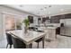 Open-concept kitchen and dining area featuring granite counters, stainless appliances, tile floor, and a view of backyard at 6731 Sumatra St, Las Vegas, NV 89166