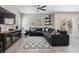 Spacious living room with a comfortable gray sectional, stylish rug, and view of the backyard through sliding glass doors at 6731 Sumatra St, Las Vegas, NV 89166