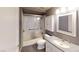 Bathroom featuring white tile, shower, and vanity with mirror and updated fixtures at 6901 Cobre Azul Ave # 202, Las Vegas, NV 89108