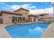 Community pool with lounge seating and stucco building in the background under sunny skies at 6901 Cobre Azul Ave # 202, Las Vegas, NV 89108