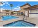 Community pool and spa featuring a nearby shower, palm trees, and lounge seating at 6901 Cobre Azul Ave # 202, Las Vegas, NV 89108