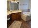 Well lit bathroom with a soaking tub and wood cabinets at 7650 Butterscotch Ct, Las Vegas, NV 89131