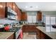 Kitchen featuring granite countertops, wood cabinets, stainless steel appliances, and adjacent breakfast nook at 7651 E Anatolian St, Las Vegas, NV 89166