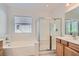 Bright bathroom with a large soaking tub, glass-enclosed shower, and wooden cabinets at 841 Colina Alta Pl, Las Vegas, NV 89138