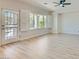 Bright living room featuring light wood flooring, an exit to a pool area and large windows with white shutters at 841 Colina Alta Pl, Las Vegas, NV 89138