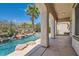 Beautiful pool area featuring a waterfall, lush plants, and an outdoor living space at 841 Colina Alta Pl, Las Vegas, NV 89138