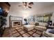 Cozy living room with a fireplace, comfortable seating, and large windows overlooking the backyard at 884 E Robindale Rd, Las Vegas, NV 89123