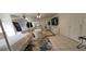 Bright living room featuring comfortable armchairs, a four-poster bed, and tile flooring at 884 E Robindale Rd, Las Vegas, NV 89123