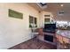 An outdoor kitchen features a built-in grill, bar seating, and tiled countertops, perfect for outdoor cooking at 884 E Robindale Rd, Las Vegas, NV 89123