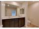 Bathroom with dual sinks, dark wood cabinets and quartz counters, bright mirror and wood-style floors at 8909 Cherry Barn St, Las Vegas, NV 89113