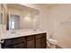 Bright bathroom boasts dual sinks, dark wood cabinets, quartz counters and an expansive mirror at 8909 Cherry Barn St, Las Vegas, NV 89113