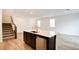 Open-concept living area with hardwood floors and a modern island with a sink and dishwasher at 8909 Cherry Barn St, Las Vegas, NV 89113