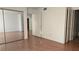 Spacious bedroom featuring wood floors, mirror closet doors and neutral paint at 9070 Spring Mountain Rd # 209, Las Vegas, NV 89117