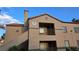 Two-story condo building with a terra cotta roof and private balconies under a blue sky in a well-maintained community at 9070 Spring Mountain Rd # 209, Las Vegas, NV 89117