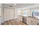 Open kitchen view with quartz counters, stainless steel sink, white cabinets and wood-look flooring at 9303 Gilcrease Ave # 1243, Las Vegas, NV 89149