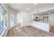 Open living room with light wood-look floors leading to the kitchen with stainless steel appliances at 9303 Gilcrease Ave # 1243, Las Vegas, NV 89149