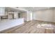 Open concept living room and kitchen area with quartz counters, white cabinets and wood-look flooring at 9303 Gilcrease Ave # 1243, Las Vegas, NV 89149