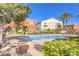 Community pool with lounge chairs, manicured landscaping, and nearby two-story residential buildings at 9303 Gilcrease Ave # 1243, Las Vegas, NV 89149