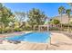 Community pool with pergola, lounge chairs, manicured landscaping, and lush mature trees at 9303 Gilcrease Ave # 1243, Las Vegas, NV 89149