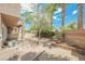 Fenced backyard featuring palm trees, desert landscaping, and a patio at 9490 Thunder Sky St # 102, Las Vegas, NV 89178