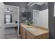 Bathroom vanity with a stone countertop, undermount sink, and view into the bedroom with hardwood floors at 10001 Peace Way # 2351, Las Vegas, NV 89147