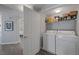 Convenient laundry area with a washer, dryer, and shelving for storage, next to an open door at 10001 Peace Way # 2351, Las Vegas, NV 89147