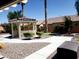 Lush backyard featuring a gazebo, landscaped gravel area, palm trees, and manicured bushes at 10015 Wonderful Day Dr, Las Vegas, NV 89148