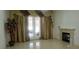 Bright living room with tiled floors, a fireplace, and large windows with elegant curtains at 10015 Wonderful Day Dr, Las Vegas, NV 89148