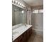 This bathroom features a dual sink vanity, shower-tub combination and a large mirror with great lighting at 10974 Fintry Hills St, Las Vegas, NV 89141
