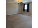 Large, carpeted bedroom featuring a ceiling fan and window with dark curtains at 10974 Fintry Hills St, Las Vegas, NV 89141