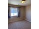 Neutral bedroom featuring carpet, a window with curtains, and simple lighting at 10974 Fintry Hills St, Las Vegas, NV 89141