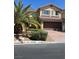 Beautiful two-story home featuring desert landscaping, a brick driveway, and a tile roof at 10974 Fintry Hills St, Las Vegas, NV 89141