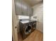Laundry room with grey cabinets and stainless steel washer and dryer units at 10974 Fintry Hills St, Las Vegas, NV 89141
