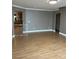 Living room with wood floors, gate, and views to the kitchen and entry hallway at 10974 Fintry Hills St, Las Vegas, NV 89141