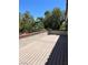 Outdoor patio with wood-look flooring and view of greenery at 10974 Fintry Hills St, Las Vegas, NV 89141