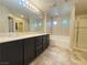 Bathroom features a double vanity, tile flooring, a soaking tub and glass enclosed shower at 11083 Ketchikan St, Las Vegas, NV 89179