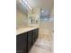Bathroom featuring double sinks, dark cabinetry, and large mirrors at 11083 Ketchikan St, Las Vegas, NV 89179