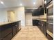 Well-equipped kitchen with stainless steel appliances, dark cabinetry, granite counters, and tile floors at 11083 Ketchikan St, Las Vegas, NV 89179