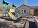 Community playground with slide and play structure near the building with stone facade and window at 11083 Ketchikan St, Las Vegas, NV 89179