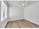 A minimalist bedroom features wood floors, white walls, and a modern ceiling fan at 124 Wynntry Dr, Henderson, NV 89074