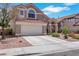 Attractive home exterior with a two-car garage and low-maintenance desert landscaping at 124 Wynntry Dr, Henderson, NV 89074