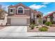 Inviting front exterior with a two-car garage, desert landscaping and tile roof at 124 Wynntry Dr, Henderson, NV 89074