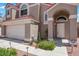 Close up on the home's front entrance featuring an arched entryway and desert landscaping at 124 Wynntry Dr, Henderson, NV 89074