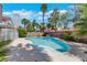 Sparkling blue swimming pool surrounded by lush landscaping and mature palm trees at 124 Wynntry Dr, Henderson, NV 89074