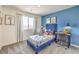 Comfortable bedroom featuring a blue accent wall and stylish decor and furnishings at 1433 Gable Falls Pl # 95, North Las Vegas, NV 89084