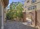 Private patio features paving stones, tall tree, block wall, and a metal gate at 1525 Spiced Wine Ave # 19103, Henderson, NV 89074