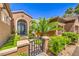 Inviting front entrance with an ornate iron gate, mature landscaping, and a covered porch at 1564 Fieldbrook St, Henderson, NV 89052