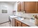 Well-lit laundry room features updated cabinetry, sink, window, and modern washer and dryer at 1564 Fieldbrook St, Henderson, NV 89052